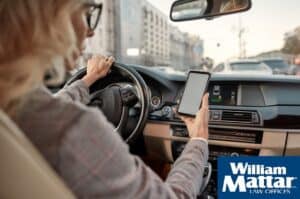 Woman looking at her cell phone while driving